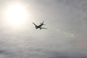 Aircraft flying with sun in background