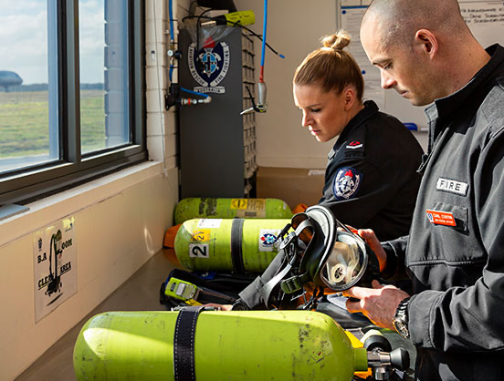 Aviation rescue fire fighters checking equipment.