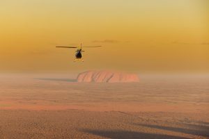 A helicopter flies over Australian desert