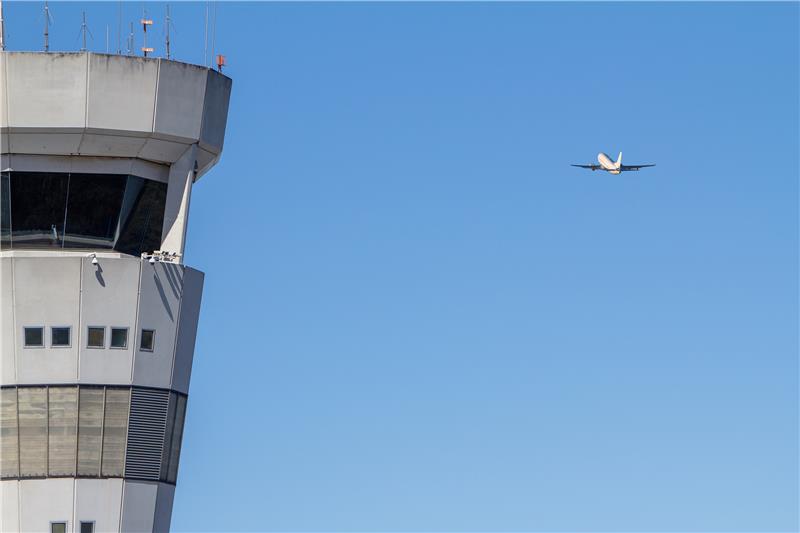 A plane flies past Brisbane Air Traffic Control Tower