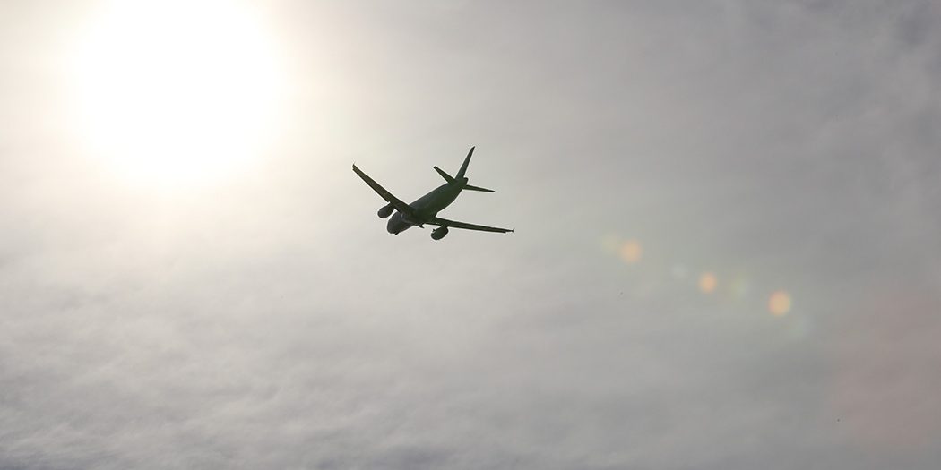 Aircraft flying with sun in background