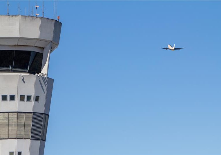 A plane flies past Brisbane Air Traffic Control Tower