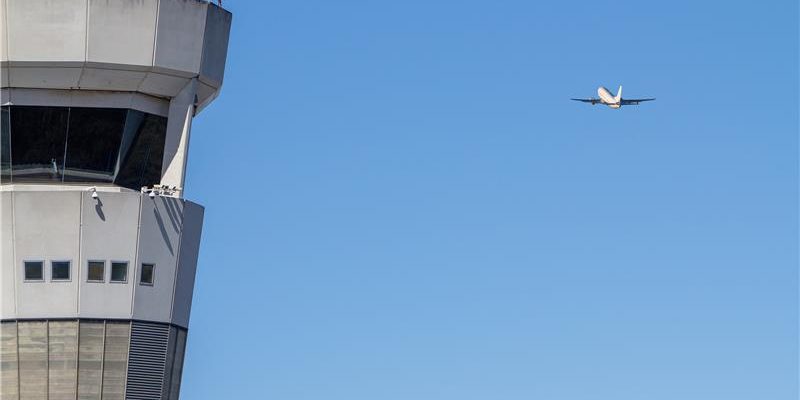 A plane flies past Brisbane Air Traffic Control Tower