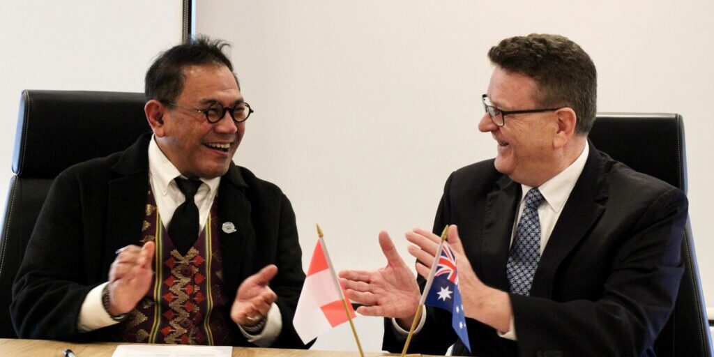 Two men sign a joint agreement