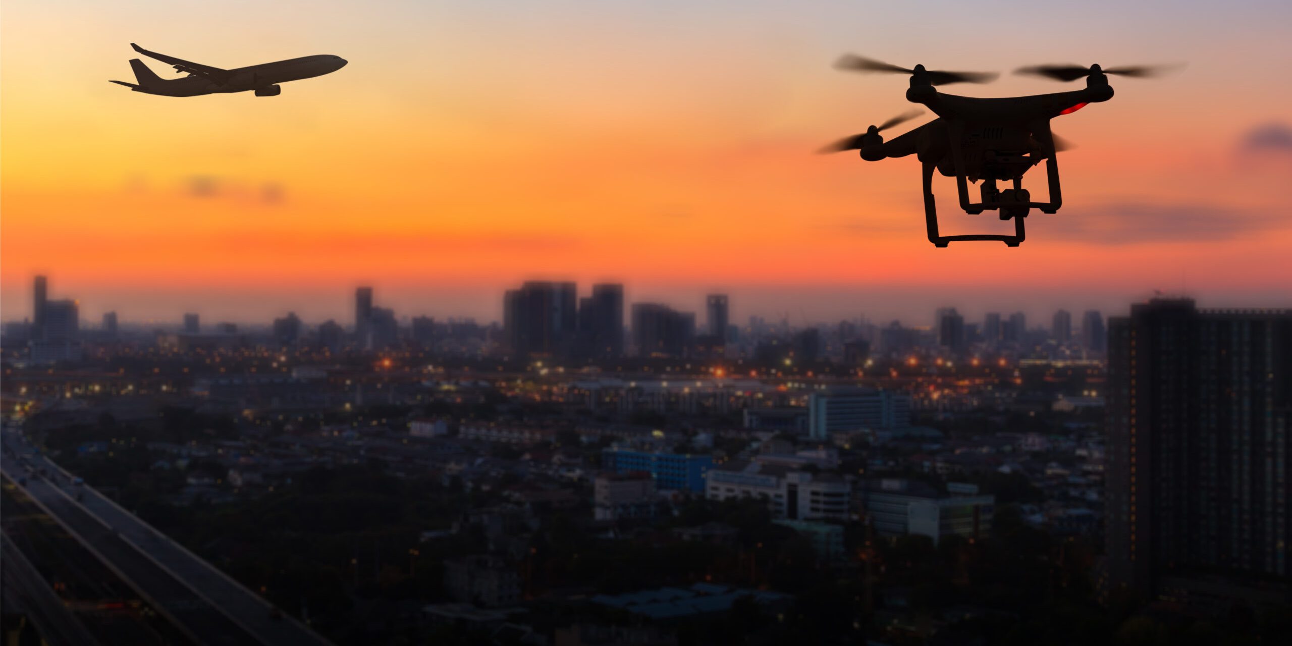 A plane and drone over sunset