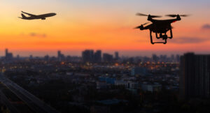 A plane and drone over sunset